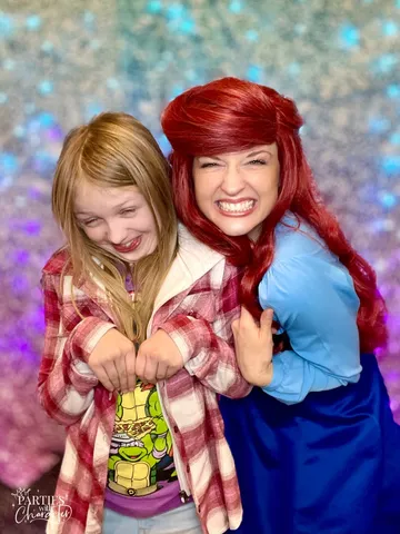 Ariel and an older girl making a playful face together