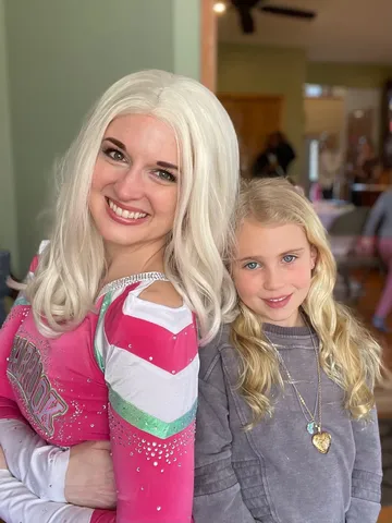 Addison standing arm in arm with a girl wearing a heart necklace