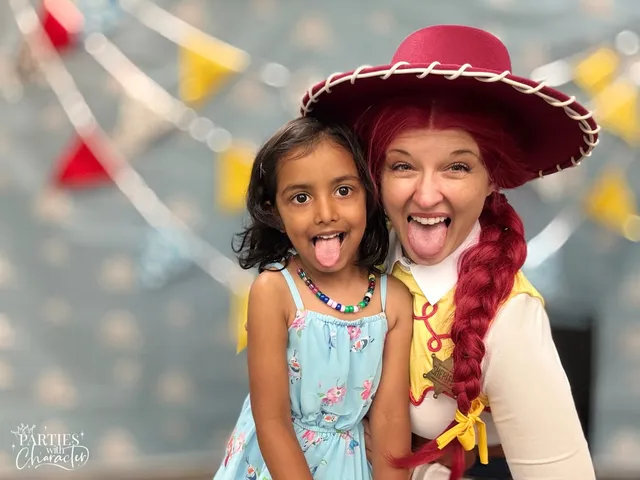 Jessie and a young girl pulling silly faces with their tongues out