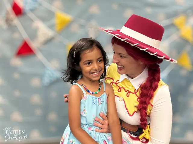 Jessie smiling down at a girl in a floral dress leaning against her