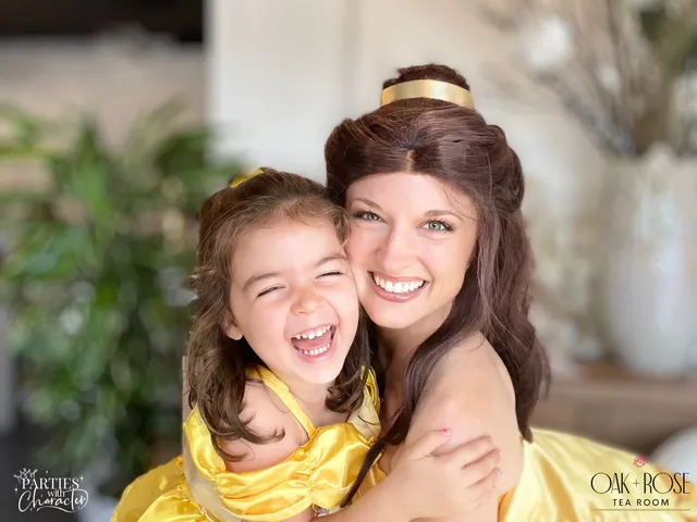 Belle laughing with a young girl among greenery at a tea room