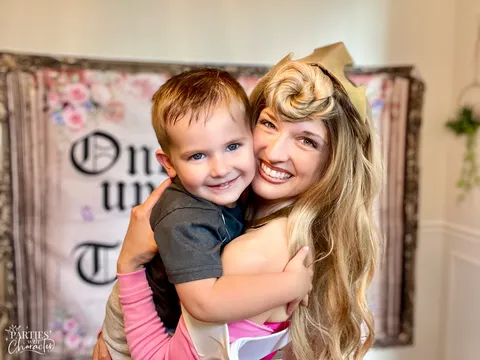 Jessica as Aurora hugging a child at a birthday party in Northern Illinois