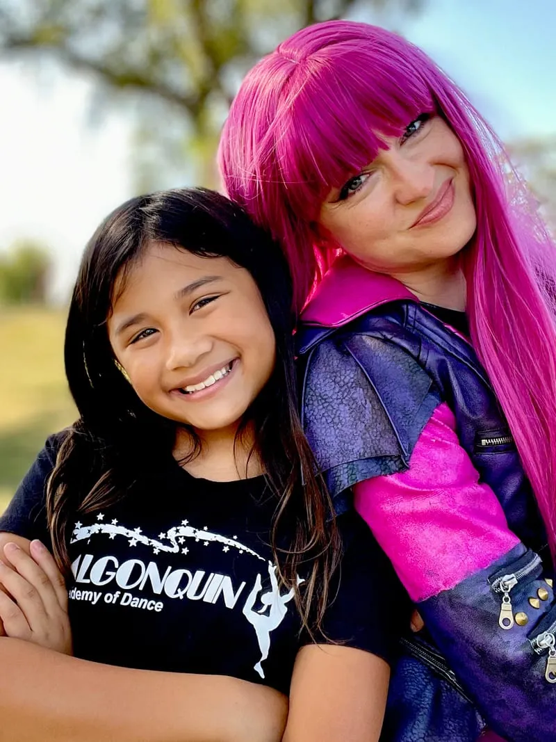 Mal hugging a girl in a black tee at an outdoor fall festival